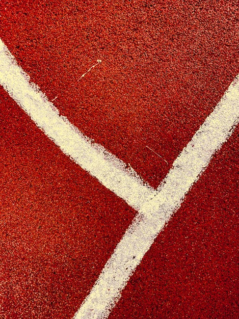 Abstract close-up of red sports court featuring intersecting white lines, perfect for backgrounds.