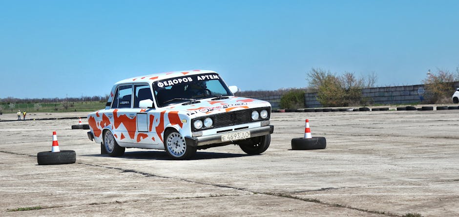 A decorated car navigates an outdoor obstacle course marked with traffic cones.